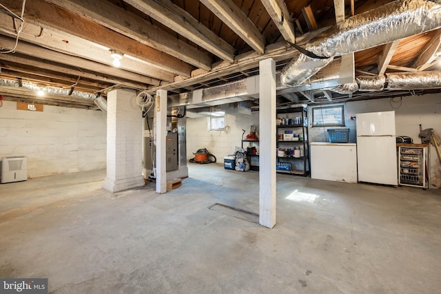 basement with white refrigerator and heating unit