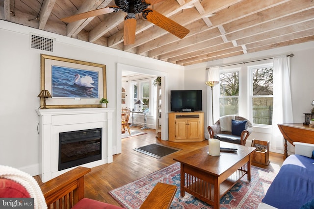 living room featuring ceiling fan, beam ceiling, hardwood / wood-style floors, and wooden ceiling