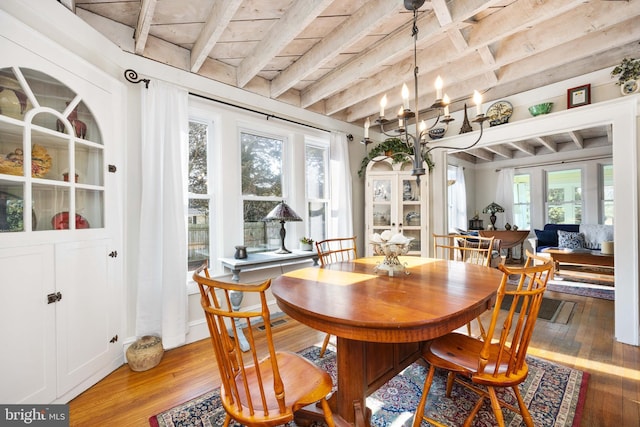 dining area featuring beamed ceiling, wood-type flooring, and wooden ceiling