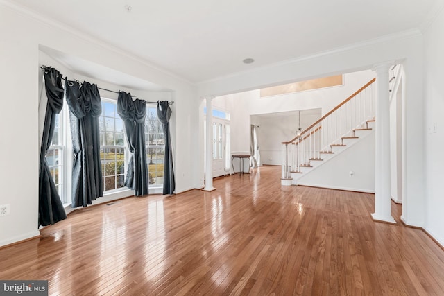 interior space featuring crown molding, decorative columns, and hardwood / wood-style floors