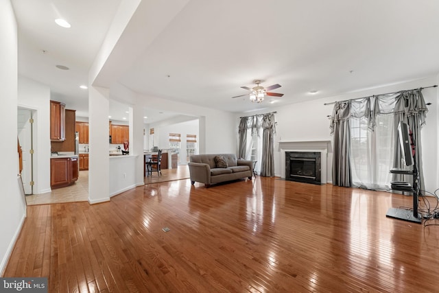 unfurnished living room featuring a healthy amount of sunlight, a premium fireplace, and light hardwood / wood-style flooring