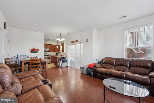 living room with dark hardwood / wood-style floors and a chandelier