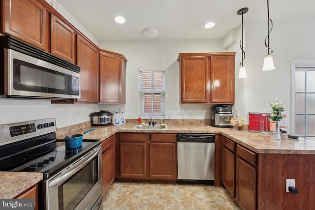 kitchen with stainless steel appliances, a healthy amount of sunlight, sink, and decorative light fixtures