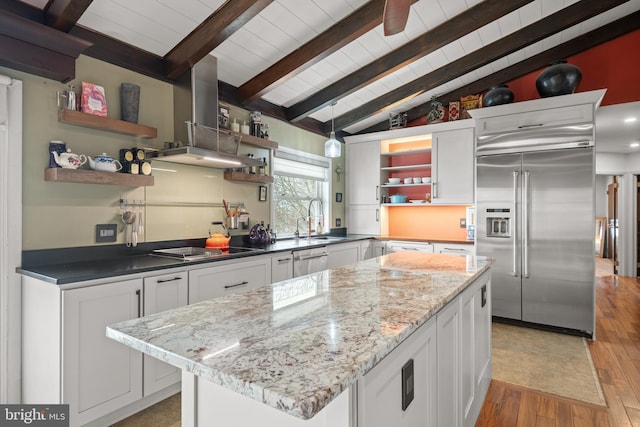 kitchen with stainless steel appliances, white cabinetry, and a center island