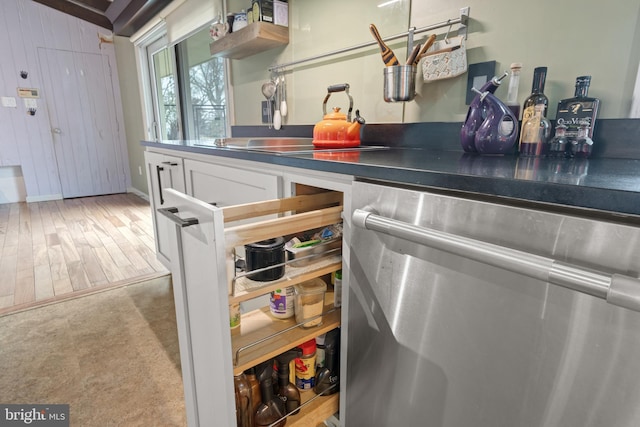 kitchen with sink, stainless steel dishwasher, and light hardwood / wood-style flooring