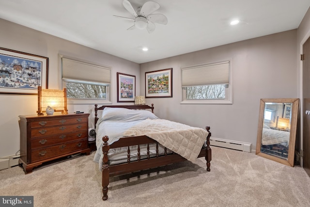 carpeted bedroom with ceiling fan and baseboard heating