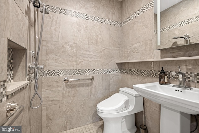 bathroom with sink, tile walls, decorative backsplash, tiled shower, and toilet