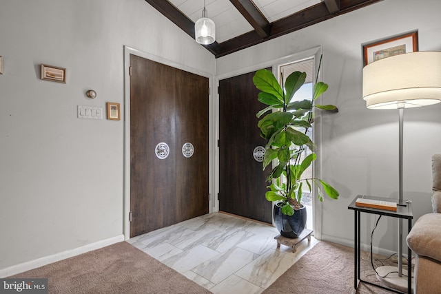 entrance foyer featuring vaulted ceiling with beams