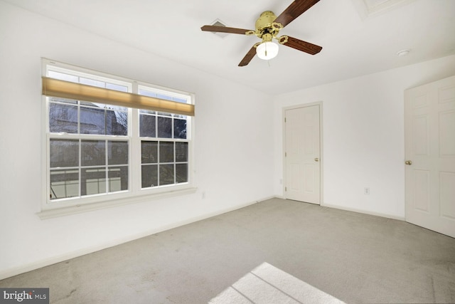 carpeted spare room with ceiling fan