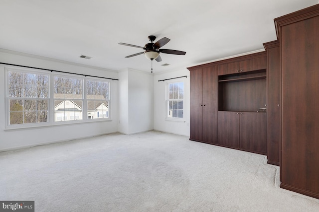 unfurnished bedroom featuring light carpet, crown molding, and ceiling fan