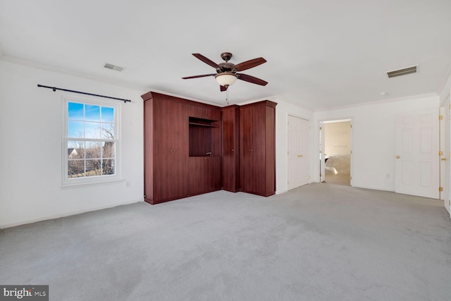 unfurnished bedroom with ornamental molding, light carpet, and ceiling fan