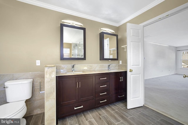 bathroom featuring vanity, crown molding, tile walls, and toilet