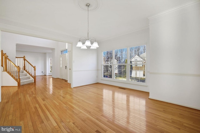 unfurnished dining area with an inviting chandelier, hardwood / wood-style flooring, and crown molding