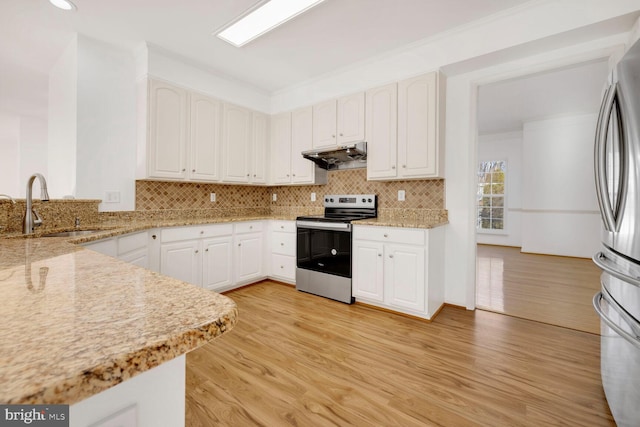 kitchen with stainless steel appliances, sink, white cabinets, and light stone counters