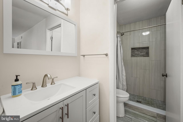 bathroom featuring walk in shower, vanity, and toilet