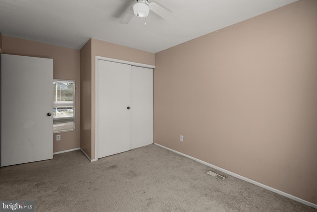 unfurnished bedroom with light carpet, a closet, and ceiling fan