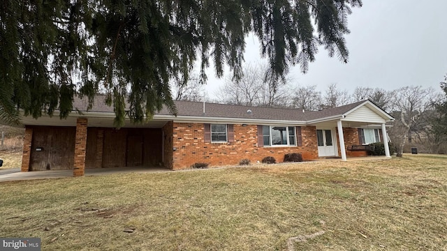 ranch-style house featuring a front yard, a carport, and covered porch