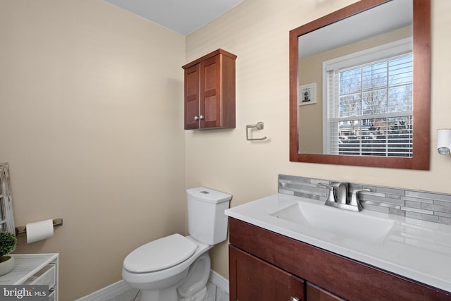 bathroom with vanity, decorative backsplash, and toilet