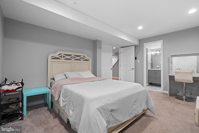 bedroom with ensuite bath and carpet floors