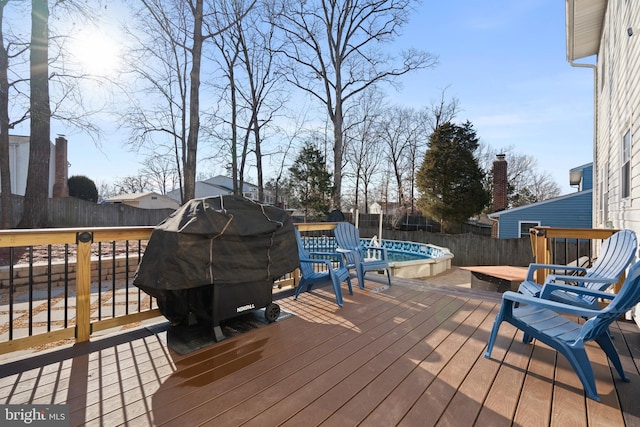 deck with a fenced in pool and grilling area