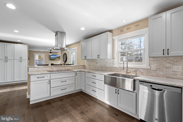 kitchen featuring island range hood, white cabinetry, sink, stainless steel dishwasher, and kitchen peninsula