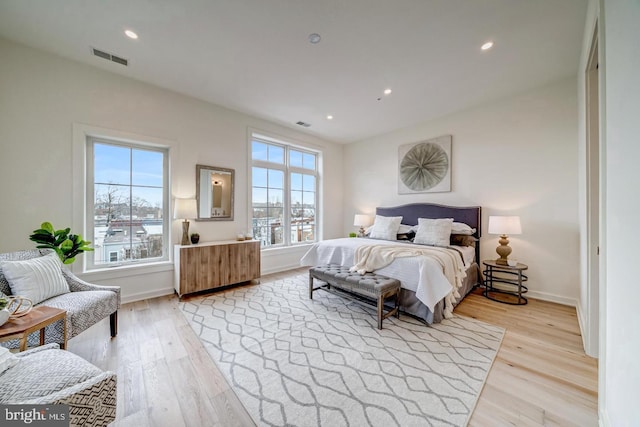 bedroom featuring multiple windows and light hardwood / wood-style floors