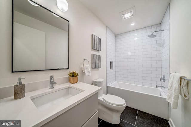 full bathroom featuring tiled shower / bath, vanity, toilet, and tile patterned flooring