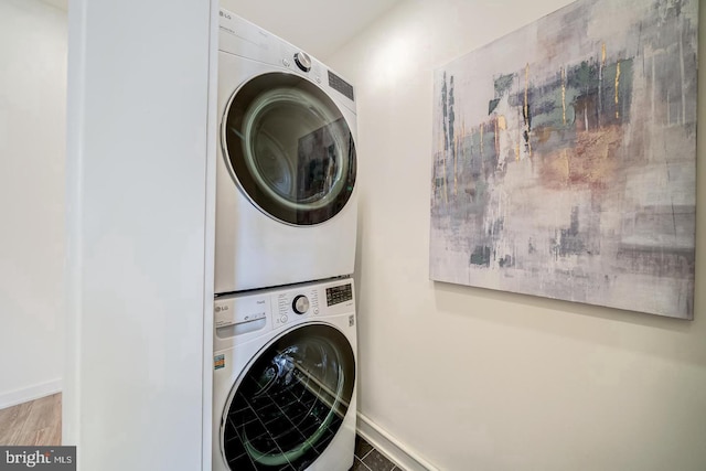 laundry area featuring hardwood / wood-style floors and stacked washer / dryer