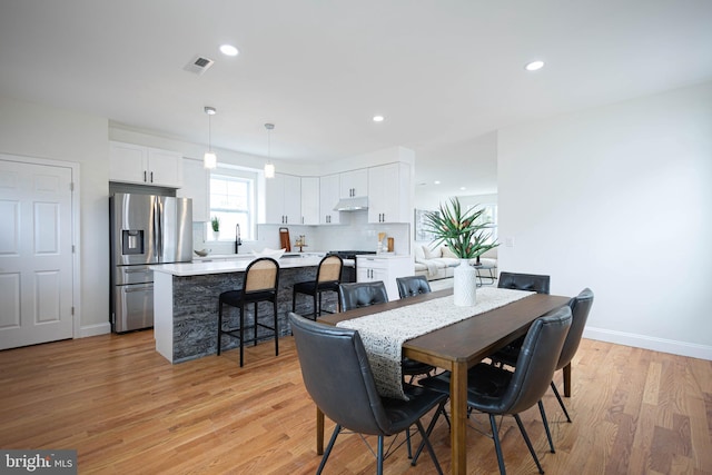 dining room with sink and light hardwood / wood-style floors