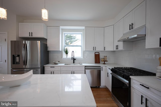 kitchen with stainless steel appliances, decorative light fixtures, sink, and white cabinets