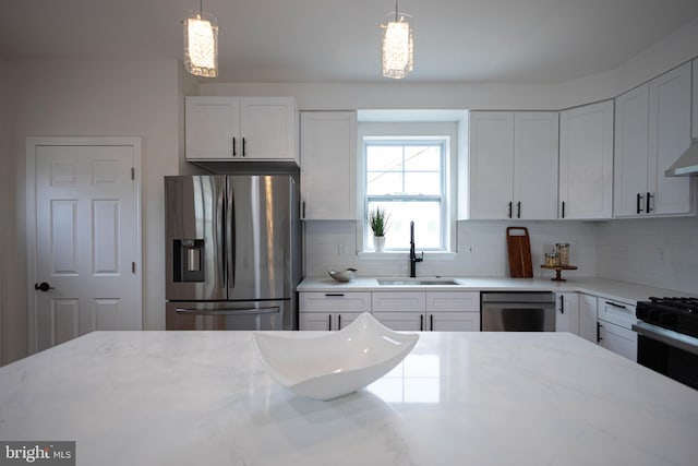 kitchen with appliances with stainless steel finishes, sink, and white cabinets