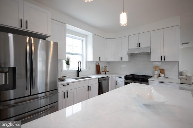 kitchen featuring sink, white cabinets, decorative backsplash, light stone counters, and stainless steel appliances