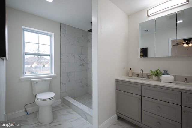 bathroom with vanity, a tile shower, and toilet