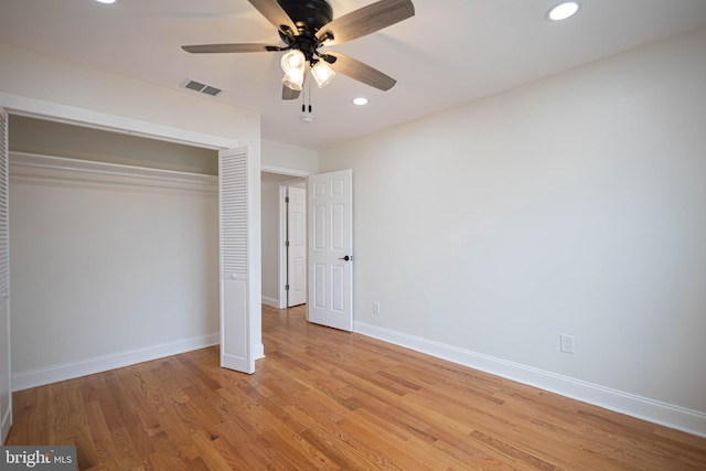 unfurnished bedroom with ceiling fan, a closet, and light wood-type flooring