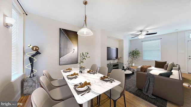 dining space featuring ceiling fan, wood finished floors, and baseboards