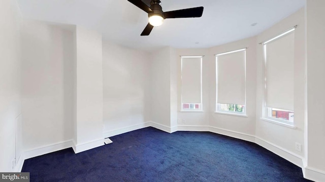 carpeted spare room featuring ceiling fan