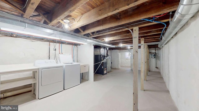 below grade area featuring heating unit and washer and dryer