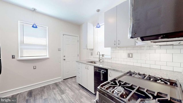 kitchen featuring white cabinetry, range with gas cooktop, sink, and hanging light fixtures