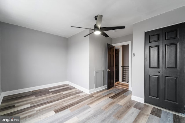 unfurnished bedroom featuring a ceiling fan, baseboards, and wood finished floors