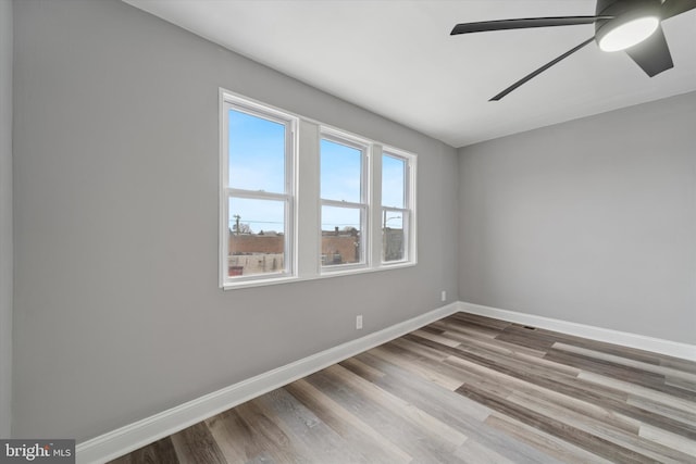 unfurnished room with ceiling fan, baseboards, and wood finished floors