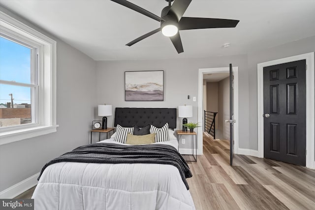 bedroom with baseboards, ceiling fan, and light wood-style floors