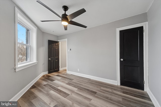 spare room with ceiling fan, baseboards, and wood finished floors