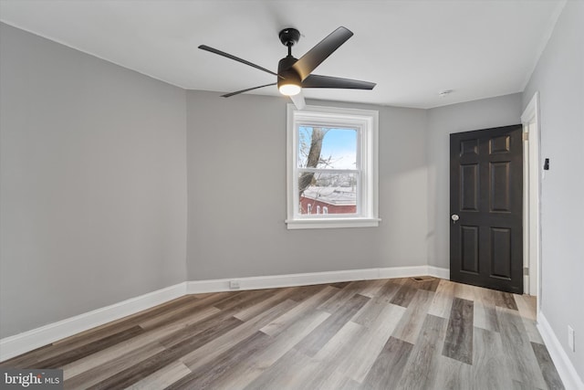 unfurnished bedroom with ceiling fan, baseboards, and wood finished floors