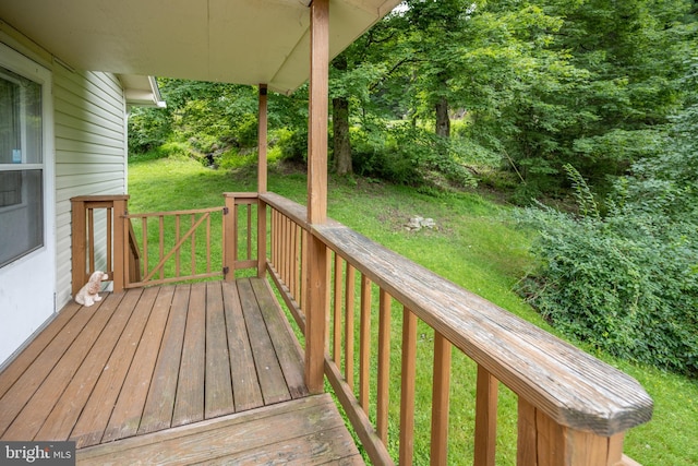 wooden terrace featuring a lawn