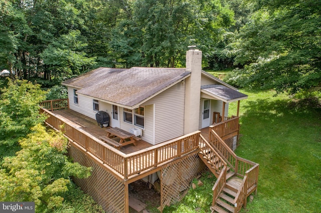 rear view of house featuring a lawn, a wall unit AC, and a deck