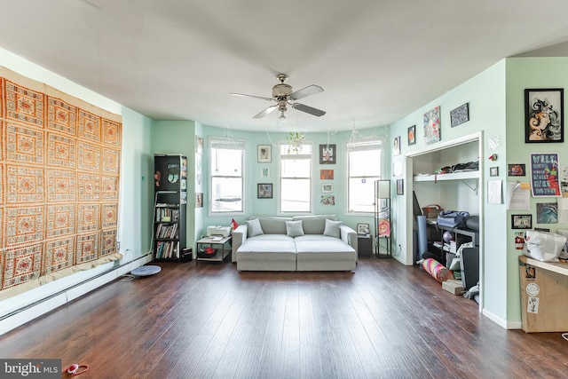 unfurnished room featuring a wealth of natural light, a baseboard heating unit, dark wood-type flooring, and ceiling fan