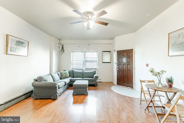 living room featuring baseboard heating, ceiling fan, and light wood-type flooring