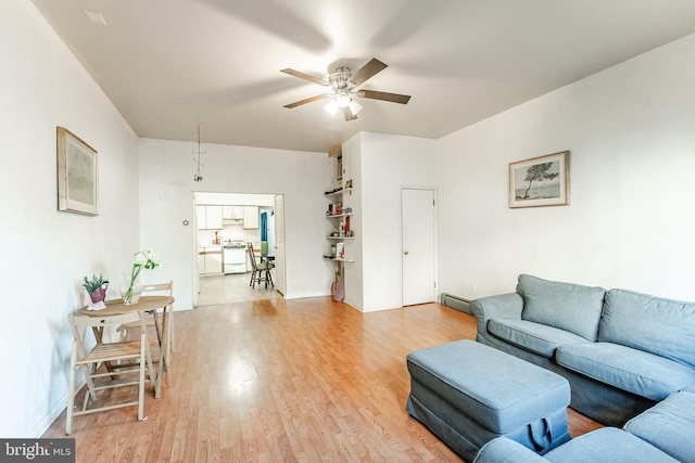 living room with a baseboard radiator, ceiling fan, and light hardwood / wood-style floors