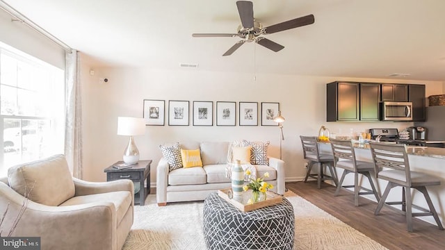 living room with wood-type flooring and ceiling fan