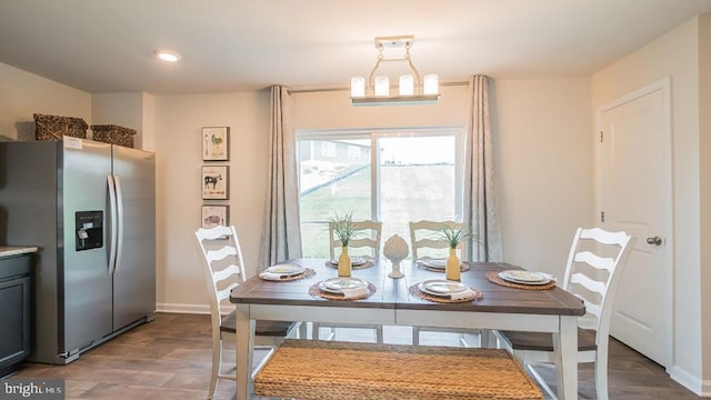 dining space with an inviting chandelier and hardwood / wood-style flooring